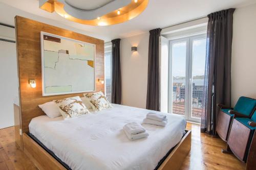 リスボンにあるLovelyStay - Stunning Penthouse with the best viewsのベッドルーム(大型ベッド1台、大きな窓付)