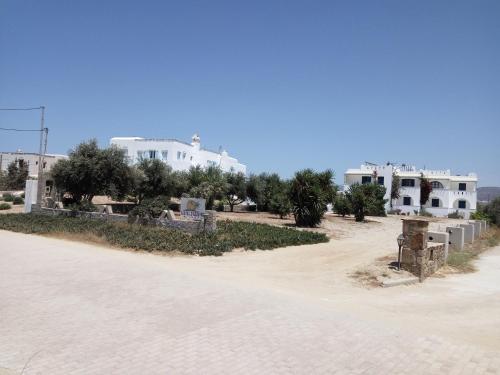 un camino de tierra frente a algunos edificios blancos en Castello Azzurro, en Agia Anna de Naxos