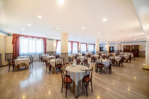 a banquet hall with white tables and chairs at Hotel Italia & Lombardi in Montefiascone