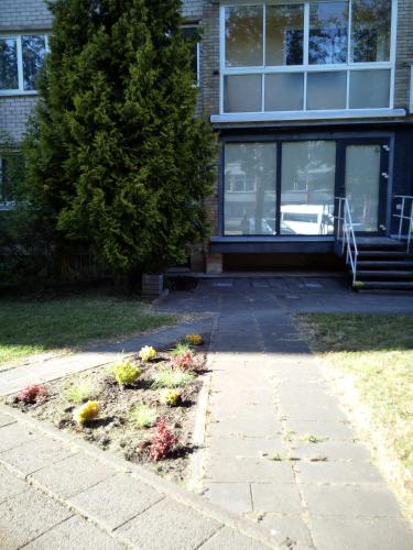 a garden in front of a house with flowers at Anykštuko butas in Anykščiai