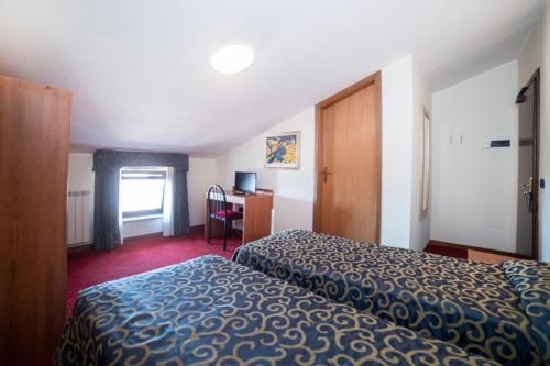 a hotel room with a bed and a desk at Hotel Italia & Lombardi in Montefiascone