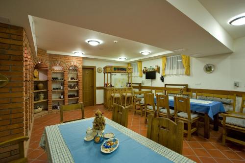 a dining room with tables and chairs and a kitchen at Penzión Paula in Tatranská Lomnica