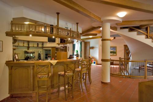 a kitchen with a bar with stools at Penzión Paula in Tatranská Lomnica