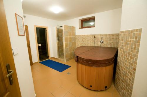 a bathroom with a large wooden tub and a shower at Penzión Paula in Vysoke Tatry - Tatranska Lomnica.