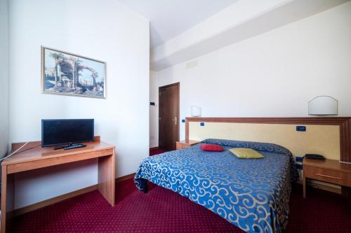 a bedroom with a bed and a desk with a computer at Hotel Italia & Lombardi in Montefiascone