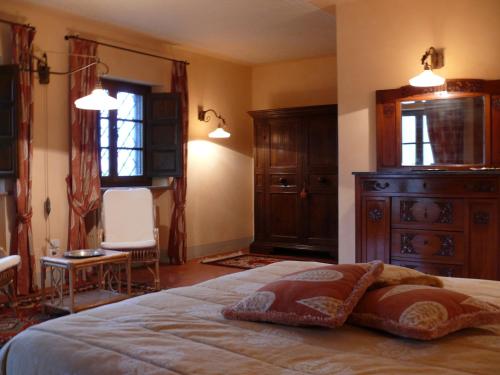 a bedroom with a bed and a dresser and windows at Le querce felici in Montegabbione