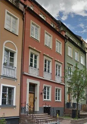 a large orange building with white windows on a street at Executive Living Östermalm Suite and Studios in Stockholm