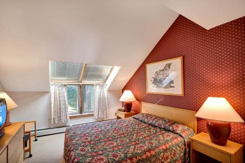 a hotel room with a bed and a window at Ski on ski off, beautiful views, 2 bedroom condo with access to indoor pool, Sunrise C5 in Killington