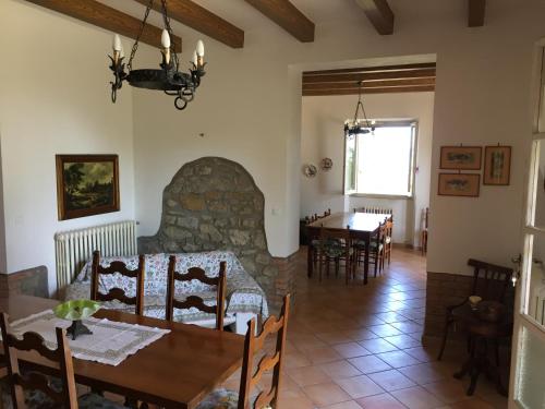 a living room with a table and a stone fireplace at Casa di Vittoria in Civitella in Val di Chiana