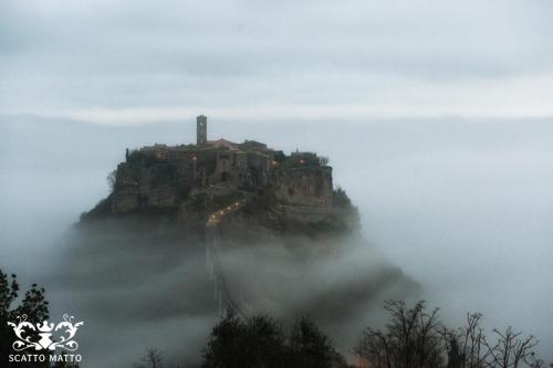 a castle on top of a mountain in the clouds at Hotel Italia & Lombardi in Montefiascone
