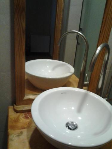 a white sink in front of a mirror at Old Tbilisi Flavor for You in Tbilisi City
