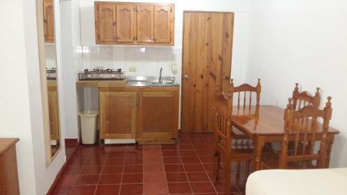 a kitchen with a table and wooden cabinets and a table and chairs at Hotel Zapata in Boca Chica
