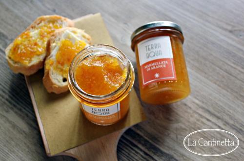 a jar of jam and a piece of bread with orange sauce at La Piazzetta in Goito