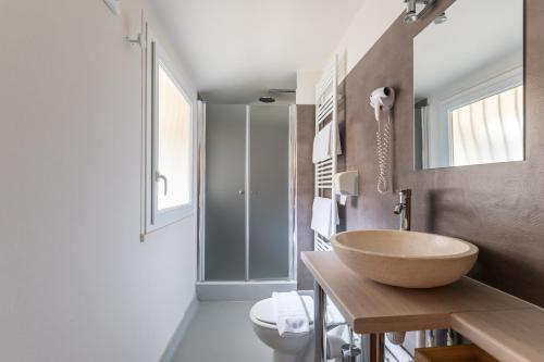 a bathroom with a bowl sink and a toilet at Logis Hôtel Lafayette Rochefort France in Rochefort