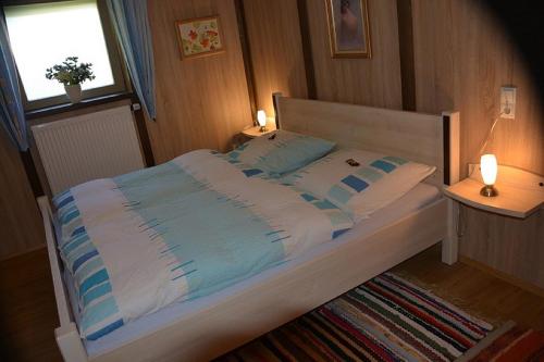 łóżko w sypialni z dwoma stołami i oknem w obiekcie Ferienwohnung Irmgard w mieście Hauzenberg