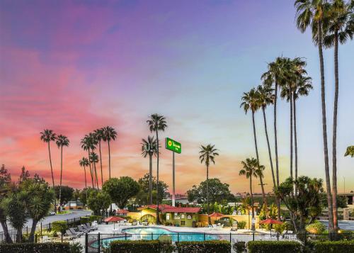 a resort with palm trees and a sign that says pool at Vagabond Inn Costa Mesa in Costa Mesa