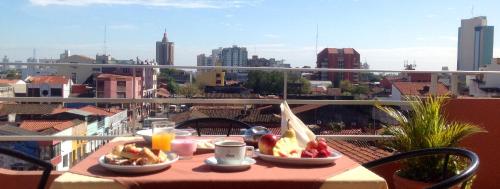 a table with food on a balcony with a view of a city at Hotel America in Santa Cruz de la Sierra