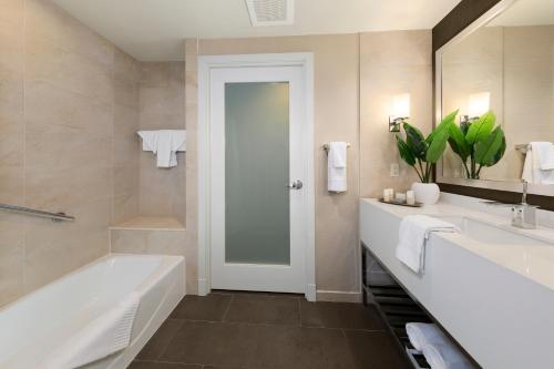 a bathroom with a tub and a sink and a mirror at The Hotel at Arundel Preserve in Hanover