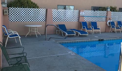 a patio with chairs and a table next to a pool at Wingate by Wyndham Farmington NM in Farmington