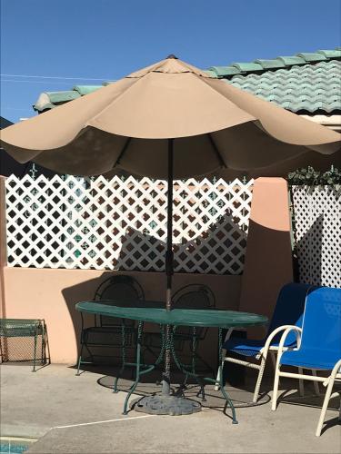 a table with an umbrella next to two chairs at Wingate by Wyndham Farmington NM in Farmington