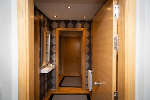 pasillo con puerta de madera y lavamanos en Apartamentos 2K - Apartamento junto al casco viejo, en Bilbao