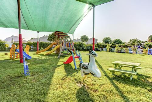 a park with a playground with a slide and a bench at Tui Magic Life Jacaranda in Side