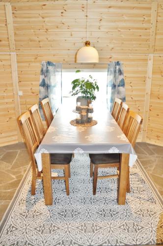 a dining room table with chairs and a potted plant at Cape Marina Lodge in Skarsvåg