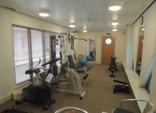 a gym with several tread machines in a room at Apartment with Swimming Pool in Tenby