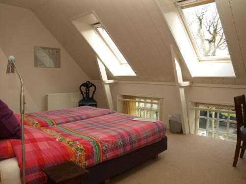 a bedroom with a bed in a room with skylights at De Jufferen Lunsingh in Westervelde