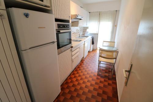une cuisine avec un réfrigérateur et une table à l'intérieur dans l'établissement 2 bedroom, 2 bathrooms, 2 mins from the Croisette, Monod 348, à Cannes