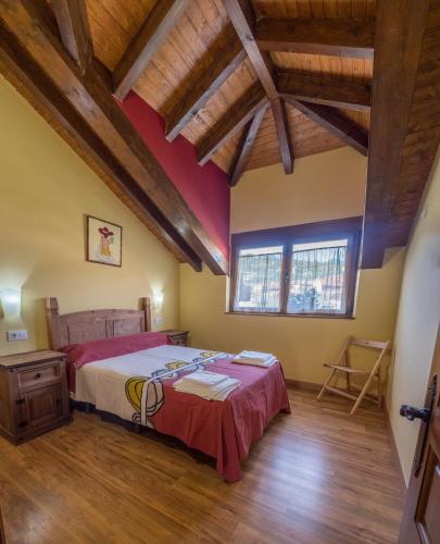 a bedroom with a bed in a room with wooden ceilings at Casa Rural El Serrano in Prioro