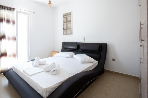 a black bed with white sheets and towels on it at Paros Central house in Parikia