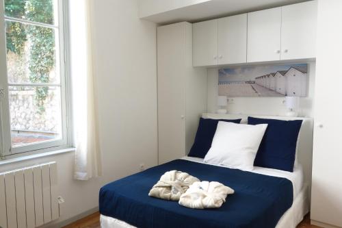 Un dormitorio con una cama azul con toallas. en Arles Holiday - Le Studio Chic en Arles
