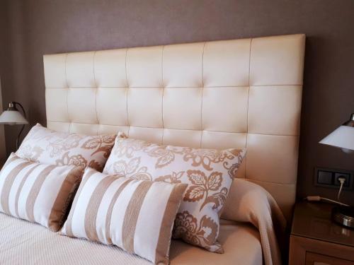 a bedroom with a white bed with two pillows at Apartamentos Esperanza del Mar in Portonovo