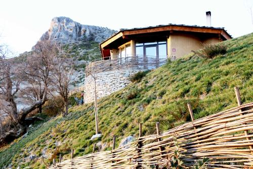 a house on top of a hill with a fence at Eco Village Under the Cliffs in Ilindentsi