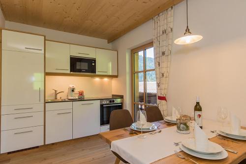 a kitchen and dining room with a table and chairs at Hinterjetzbachhof in Maria Alm am Steinernen Meer
