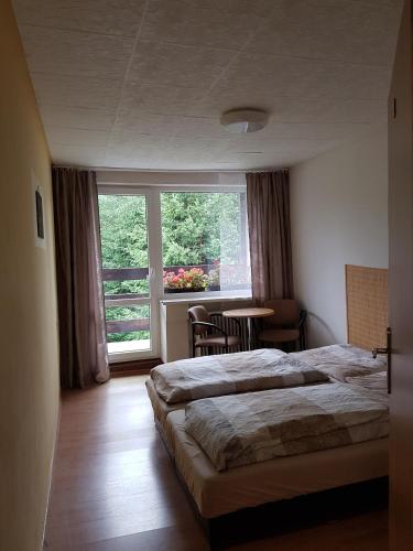 una camera da letto con un letto, un tavolo e una finestra di Vila Valéria a Tatranská Lomnica
