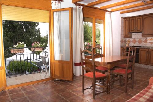 ein Esszimmer mit einem Tisch und einem Balkon in der Unterkunft AT Restaurante El Palacil in Vélez-Blanco