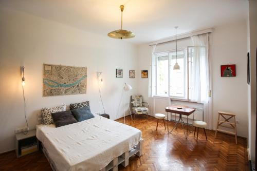 a bedroom with a bed and a table and a window at Bright Lights, Big City Studio in Budapest