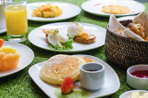 a table topped with plates of breakfast foods and drinks at Biohotel Organic Suites in Bogotá