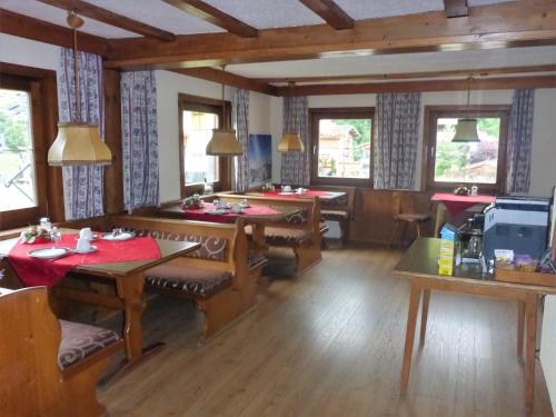 a dining room with tables and chairs and windows at Sportpension Penhab in Saalbach Hinterglemm
