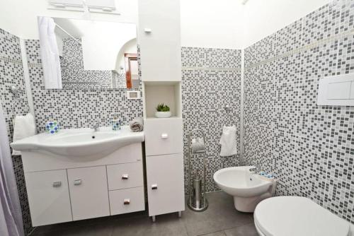 オストゥーニにあるCasa Victoriaの白いバスルーム(洗面台、トイレ付)