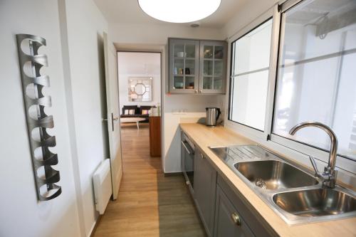 une cuisine avec un évier et une fenêtre dans l'établissement Arcachon Balsamo plage, à Arcachon