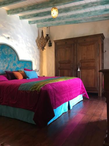 una camera con un grande letto con copriletto viola di Casa Alegría a Los Valles