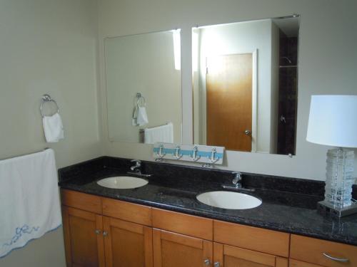 a bathroom with two sinks and a large mirror at Calfia Condo in Rosarito