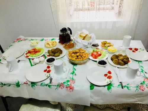 a table with plates of food on it at Denis GuestHouse 1930 in Gjirokastër