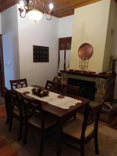 a dining room with a table and a fireplace at Village House in Agios Lavrentios