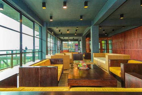 a restaurant with couches and tables and windows at Oak Ray Tea Bush in Ramboda