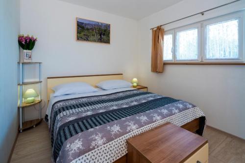 1 dormitorio con 1 cama y 2 ventanas en Apartments Intrada en Podstrana