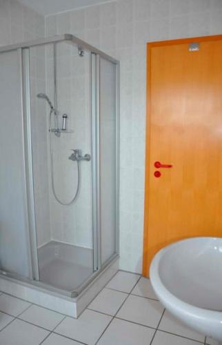 a bathroom with a shower and a tub and a sink at Haus Ostseeglück Silbermöwe Whg IV 9152I - Fehmarn in Gollendorf